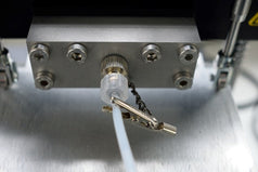 Male end of the PTFE dispensing tube connected to the Luer Lock on the slot-die head with safety clip attacehd to the tubing